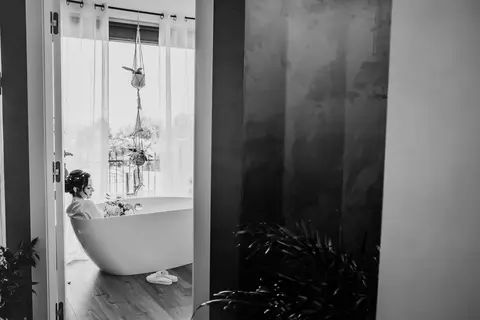La sposa Erika in bagno, seduta in una vasca da bagno bianca.