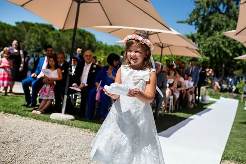 La sposa Federica in abito bianco con corona di fiori cammina lungo l'altare.