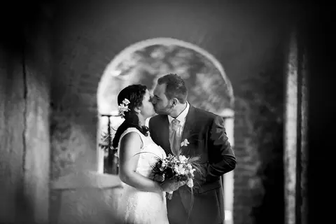 La sposa Federica e lo sposo Daniele si baciano in un arco.