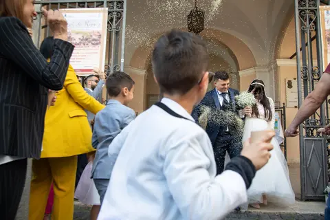 Gli sposi Silvia e Geraldo escono tra i festeggiamenti degli invitati.