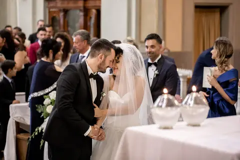 Gli sposi Giulia e Mario si abbracciano in chiesa tra gli invitati.