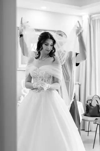 La sposa pronta, con velo e guanti, in bianco e nero
