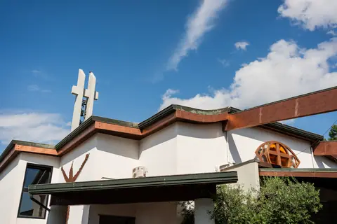 L'esterno della chiesa moderna con la croce sul tetto, sotto il cielo sereno