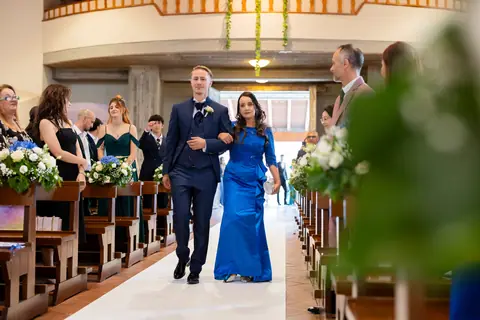 Lo sposo e la mamma percorrono la navata tra gli invitati in piedi