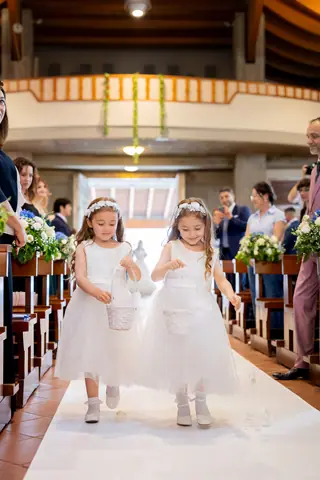 Le bambine dei fiori camminano lungo la navata con i cestini