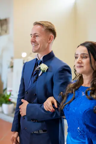 Lo sposo sorride accanto alla mamma prima dell'ingresso della sposa