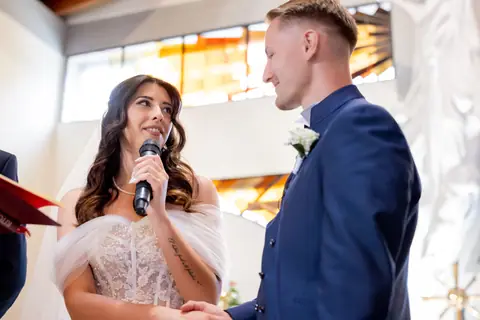 La sposa legge le promesse al microfono guardando lo sposo