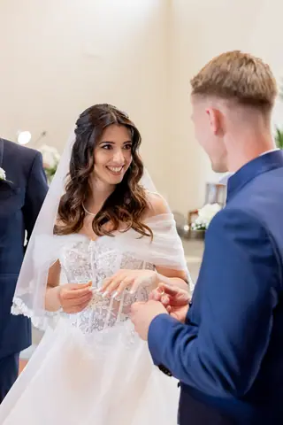 Lo sposo infila la fede al dito della sposa