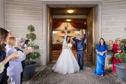 Gli sposi salutano gli invitati davanti al portone della chiesa