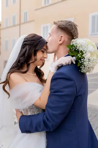 La sposa appoggia la fronte al viso dello sposo, ritratto ravvicinato
