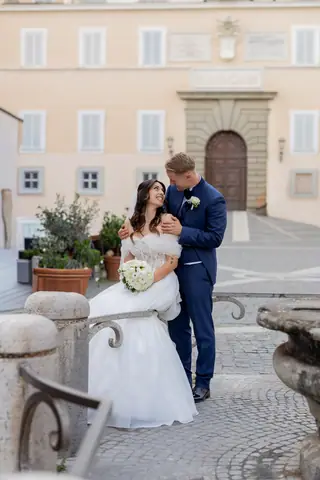 Gli sposi appoggiati alla ringhiera di pietra della piazza