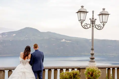 Gli sposi abbracciati accanto al lampione della terrazza sul lago
