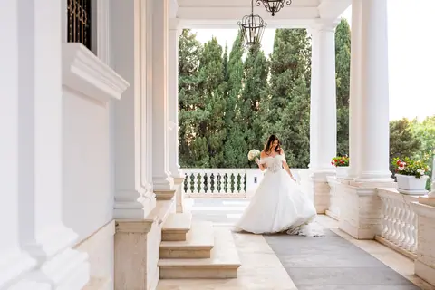 La sposa in piedi tra le colonne del porticato, ripresa da lontano