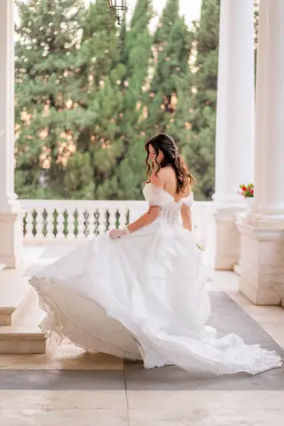 La sposa fa volare il tulle dell'abito tra le colonne