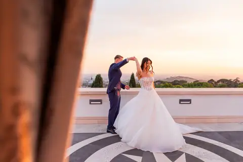 Lo sposo fa girare la sposa sulla terrazza al tramonto