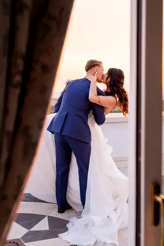 Il bacio degli sposi visto dalla porta finestra della villa