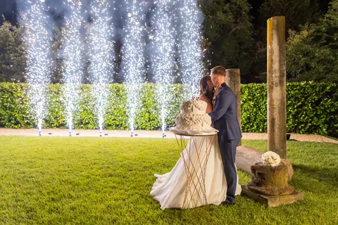 Gli sposi davanti alla torta con le fontane luminose