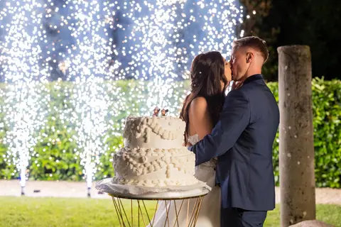 Il bacio degli sposi mentre tagliano la torta tra le scintille