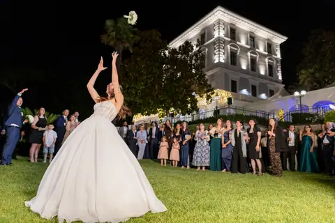 La sposa lancia il bouquet tra gli invitati in cerchio