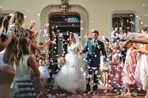 Gli sposi camminano tra gli invitati sotto una pioggia di coriandoli