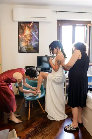 Le amiche aiutano la sposa a sistemare l'abito
