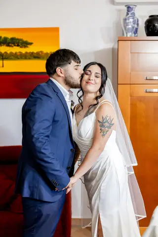 Lo sposo abbraccia la sposa in casa prima di uscire