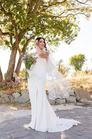 Ritratto della sposa sotto un albero con il velo lungo