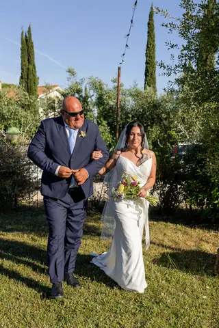 La sposa a braccetto del padre sul prato