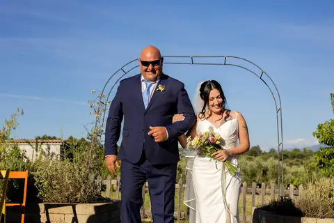 La sposa e il padre camminano verso l'altare nel vigneto