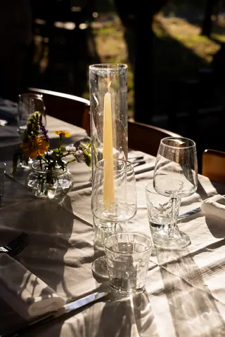 Dettaglio della candela e dei bicchieri sul tavolo