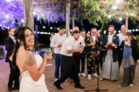 La sposa con un calice tra gli invitati durante la festa serale