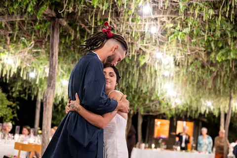 Gli sposi abbracciati durante la festa sotto le luci