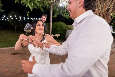 Un invitato brinda ridendo tra i tavoli