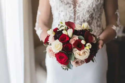 Il bouquet di rose rosse e bianche della sposa