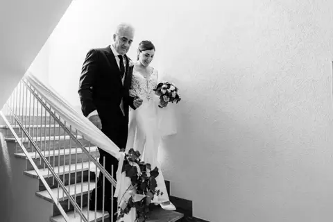 La sposa scende le scale con il papà, bianco e nero