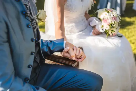 Dettaglio delle mani degli sposi che si stringono durante il rito