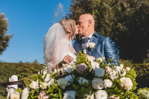 Un bacio tra gli sposi davanti al tavolo del rito