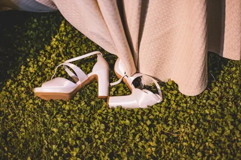 Le scarpe della sposa appoggiate sul prato durante la festa