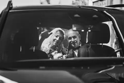 La sposa e il padre in auto ripresi in bianco e nero dal parabrezza