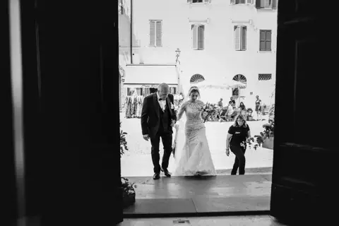 Ingresso in chiesa della sposa con il padre visto in controluce dal portale