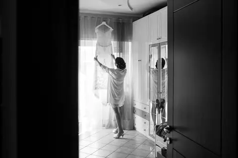 La sposa Veronica indossa un accappatoio e regola la sua sposa davanti a uno specchio.