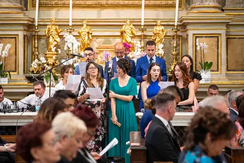 Gli sposi Veronica e Daniele cantano con il coro in chiesa.